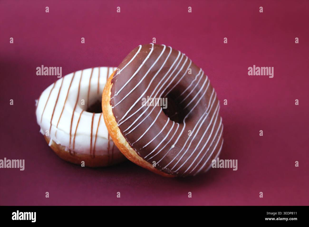 Pane dolce mennonita (ciambelle glassate) su sfondo infinito bordeaux. Pan dulce menonita (donas glaseadas) en fondo infinito vino. Chihuahua, México Foto Stock