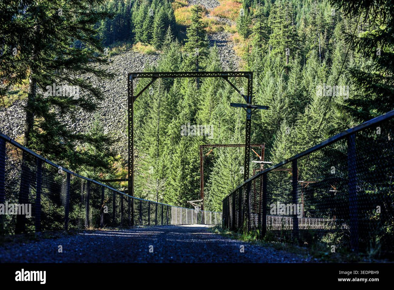 Gravel Trail che attraversa uno storico High Bridge con cornici industriali in acciaio nelle Cascade Mountains Foto Stock