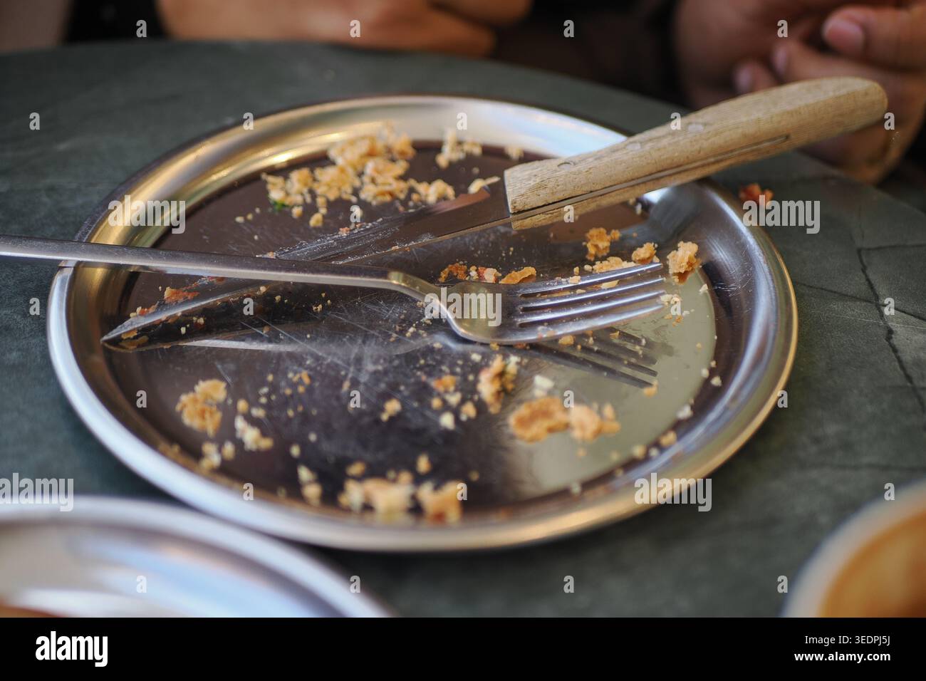 Svuotare il piatto con forchetta e coltello su un tavolo dopo un pasto Foto Stock