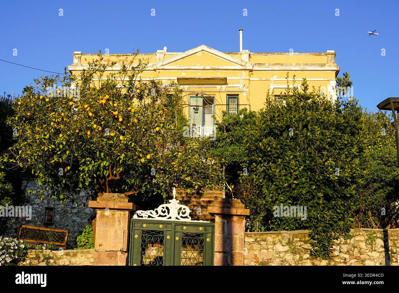Residenza neoclassica gialla con porta di ferro ornata e alberi di limone, Mytilini, Lesbo, Grecia Foto Stock