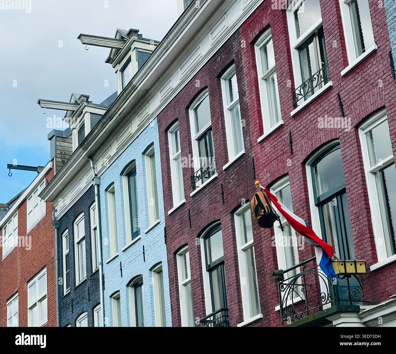 Bandiera olandese con borsa scolastica in casa residenziale nei Paesi Bassi. Tradizione olandese che celebra la laurea degli studenti delle scuole superiori. Edificio di appartamenti Foto Stock