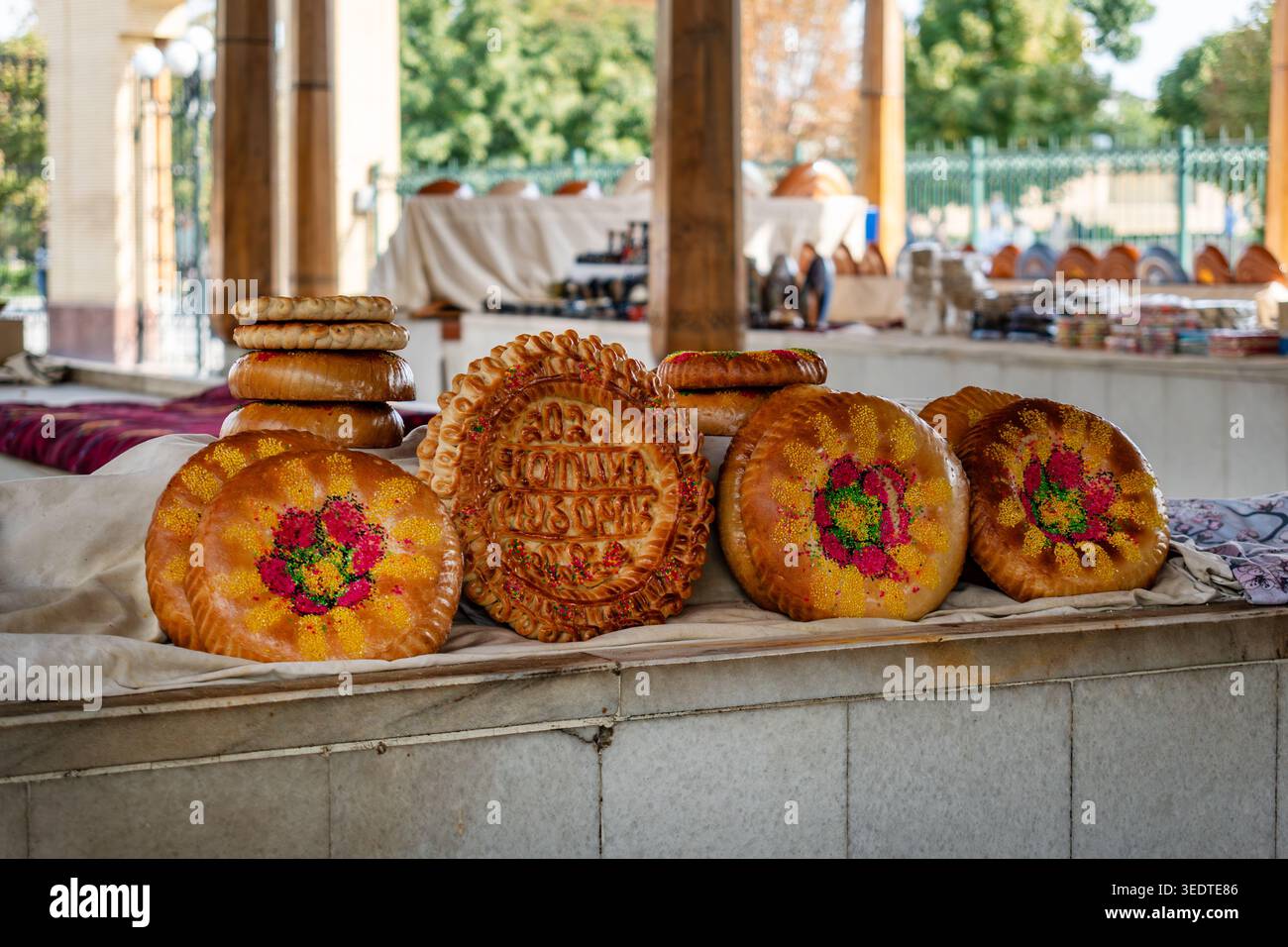 Pane piatto uzbeko tradizionale per matrimoni in un bancone del mercato a Samarcanda, Uzbekistan. Pane rotondo con crosta a motivi geometrici. Righe impilate. Foto Stock