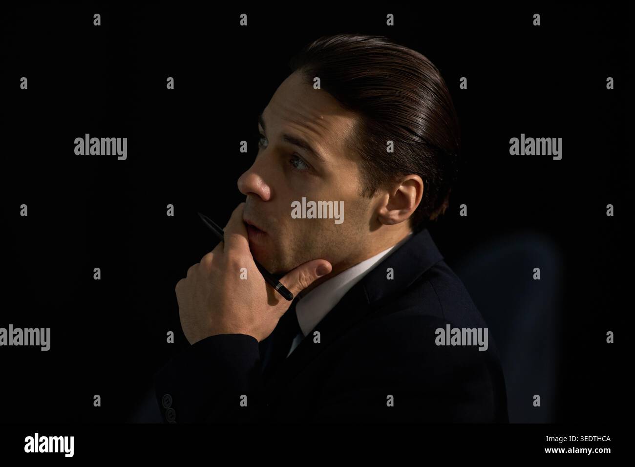 Uomo d'affari che tiene la penna e pensa durante la pianificazione strategica Foto Stock