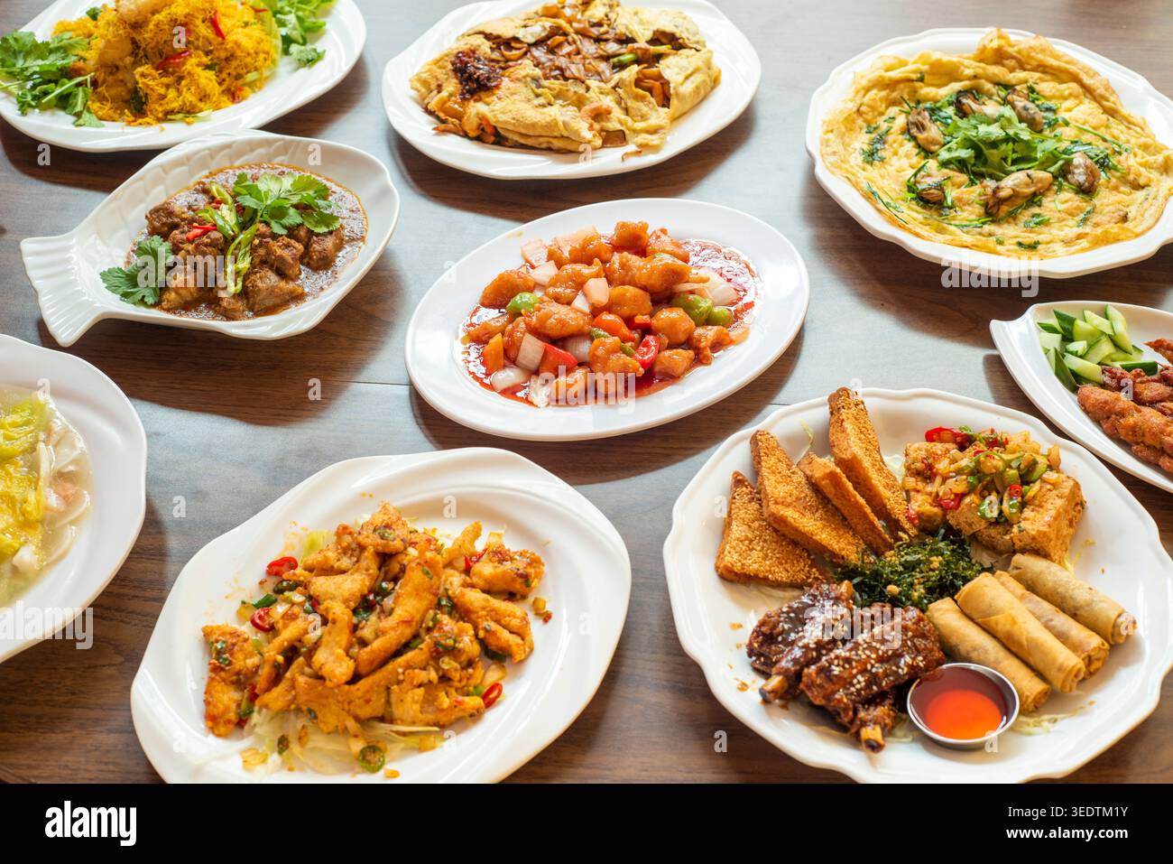 Selezione di cucina cinese e malese che include pollo dolce e acido, tagliatelle Koay Teow, pollo al sale e al peperoncino, omelette di ostriche e pasta mista Foto Stock