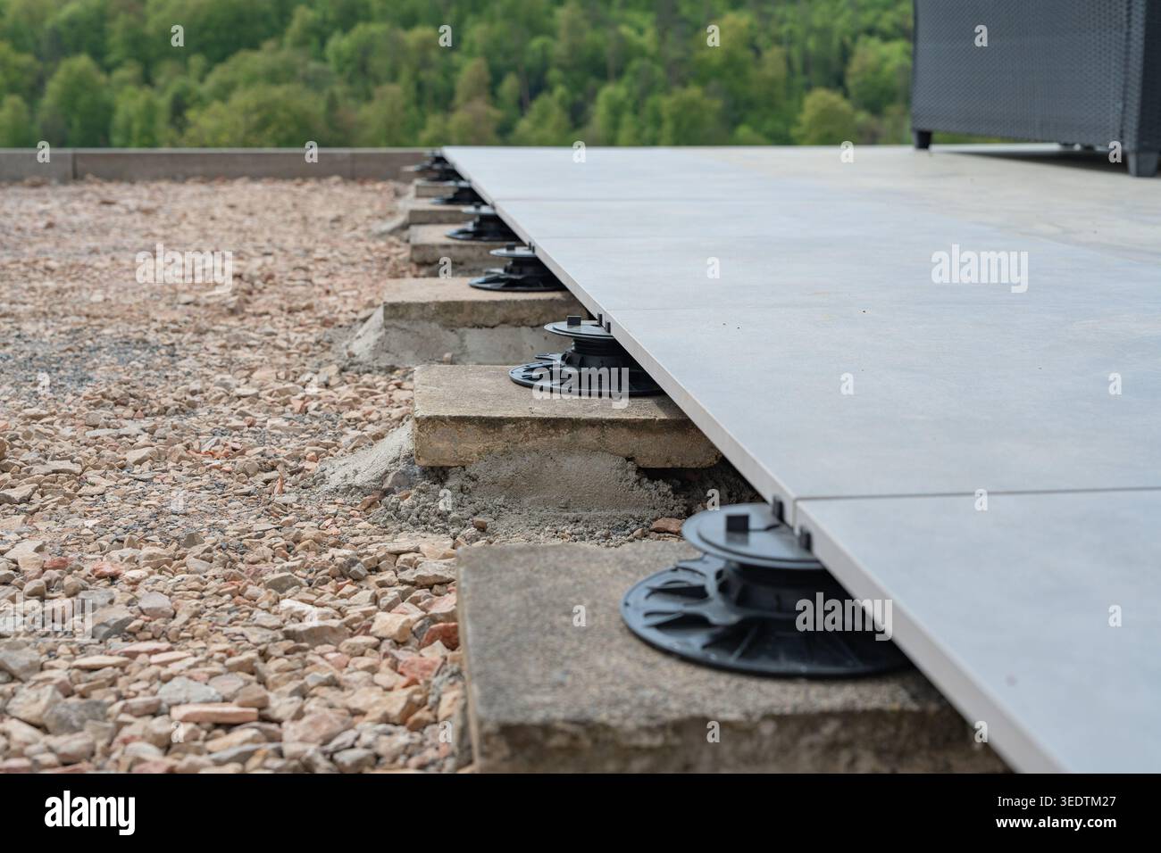 Primo piano di un piedistallo regolabile utilizzato per livellare un ponte di terrazze. Il sistema consente un controllo preciso dell'altezza e garantisce stabilità anche all'aperto Foto Stock