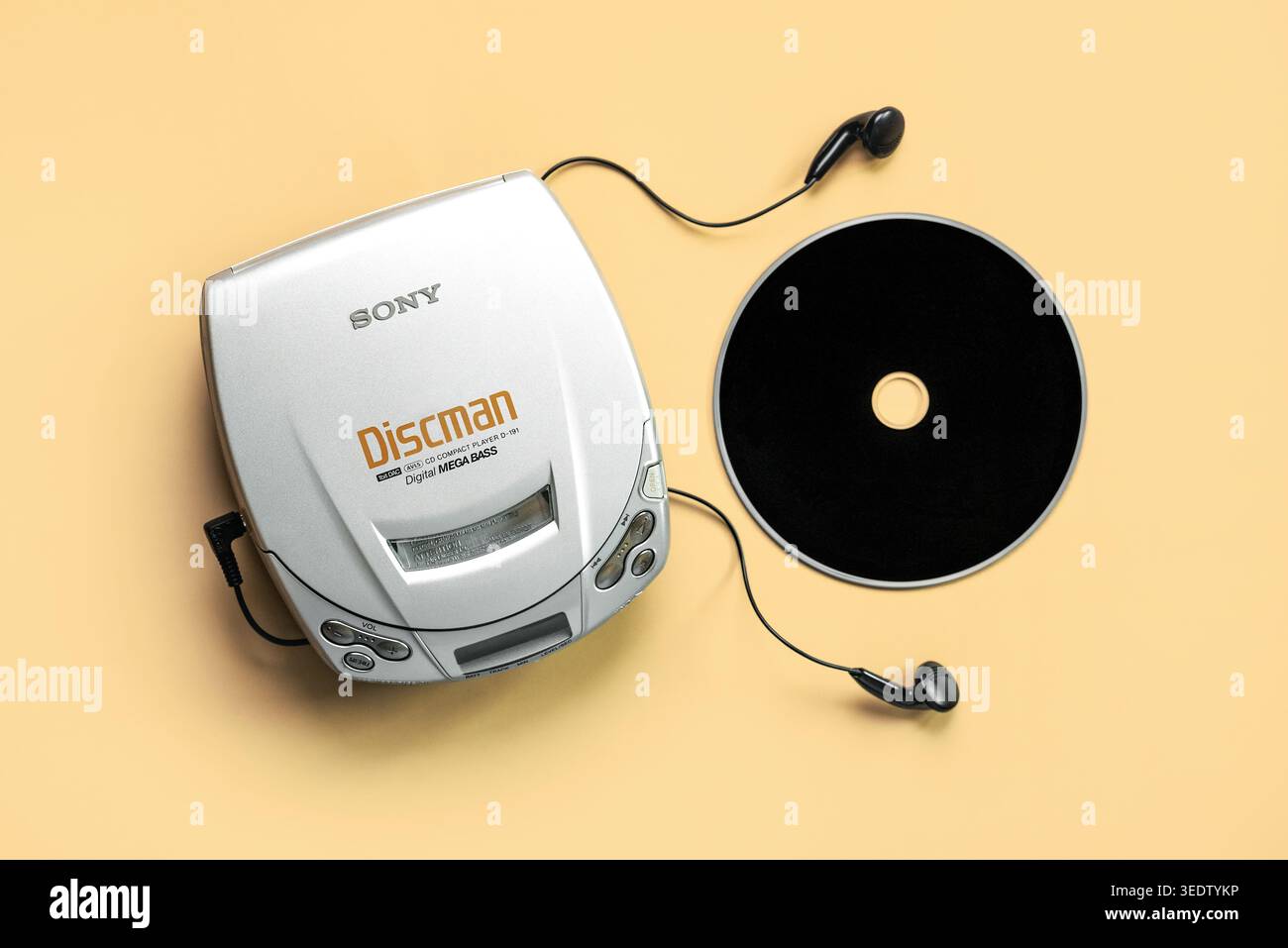 Vista dall'alto del lettore CD portatile Sony Discman con cuffie e CD musicali su sfondo giallo. Editoriale illustrativo Foto Stock