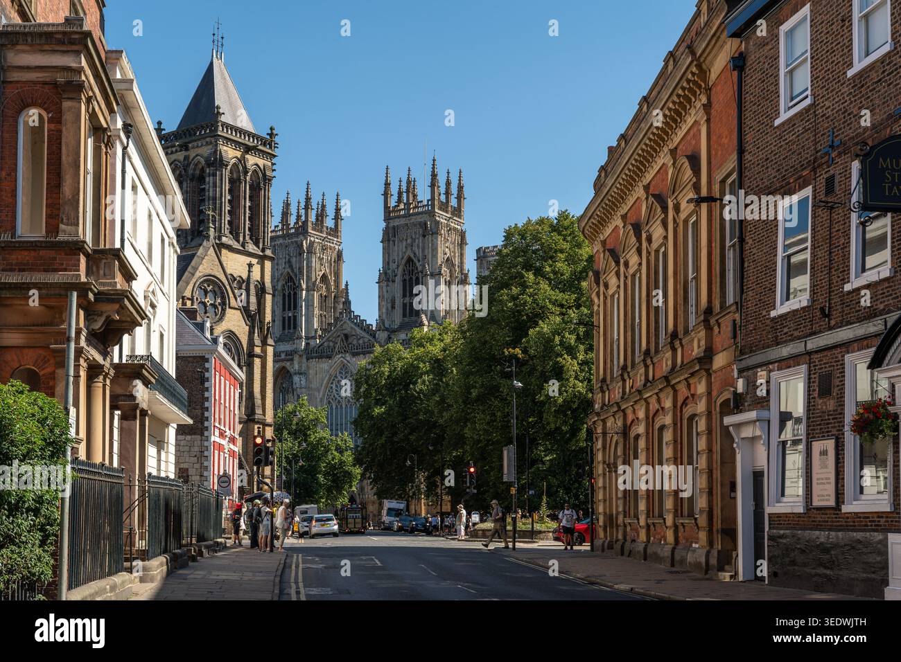 Una strada a York che conduce verso le torri della Cattedrale di York in un giorno d'estate soleggiato, in Inghilterra Foto Stock