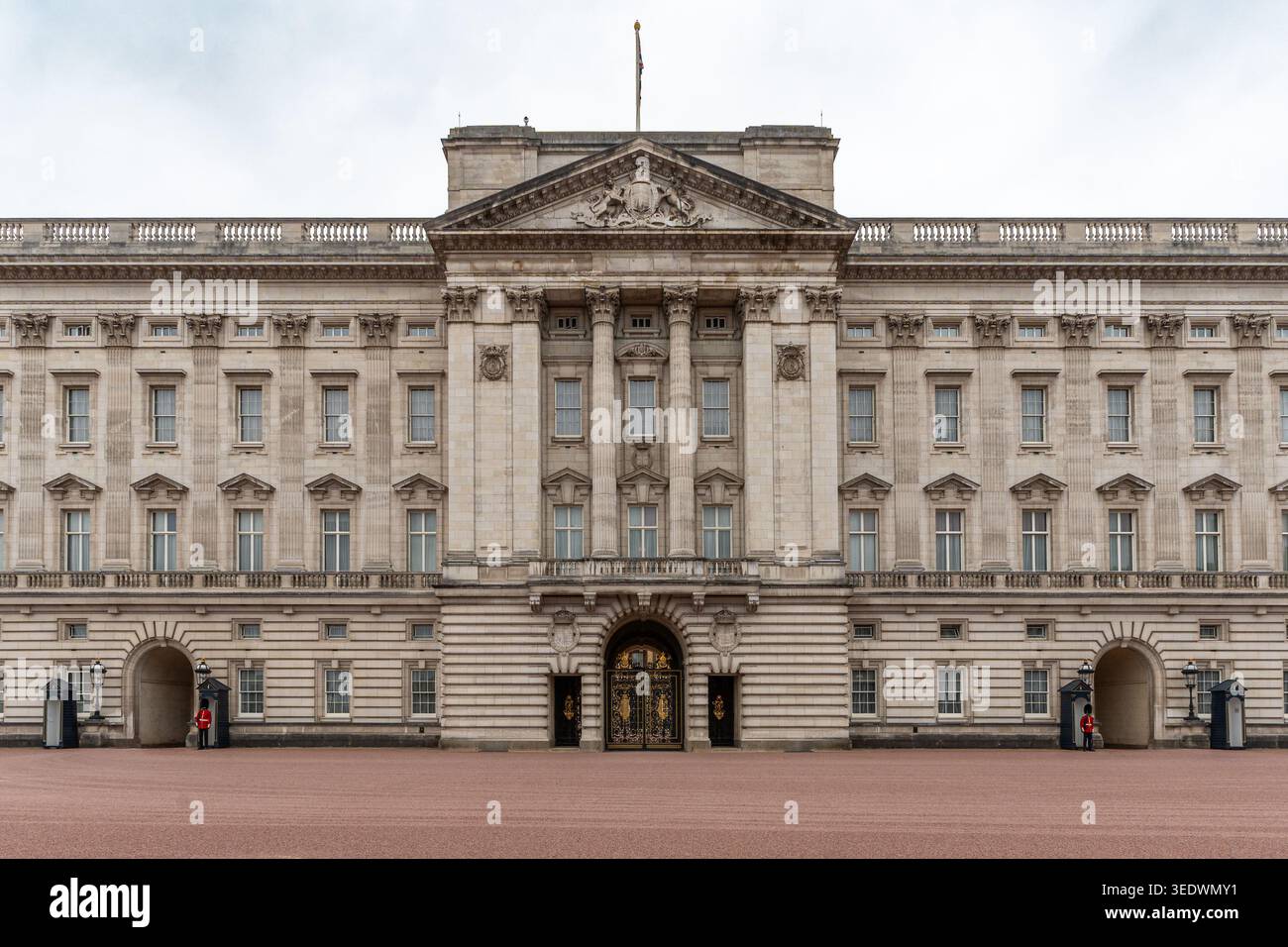 La grande facciata di Buckingham Palace a Londra con le guardie reali in piedi ai loro posti Foto Stock