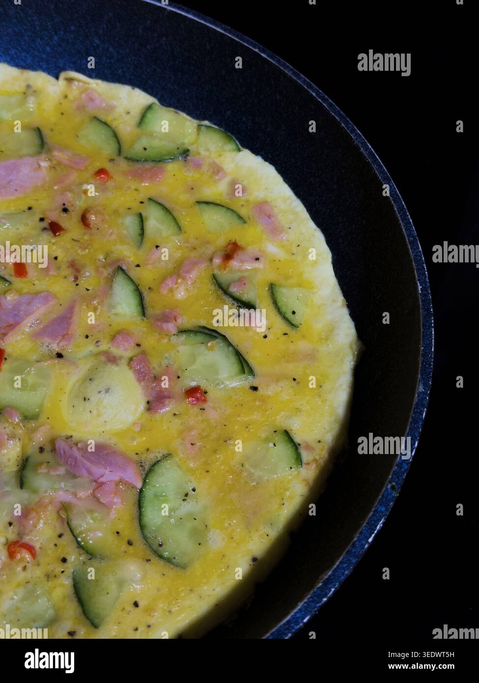 Un'omelette in una padella che viene cucinata Foto Stock