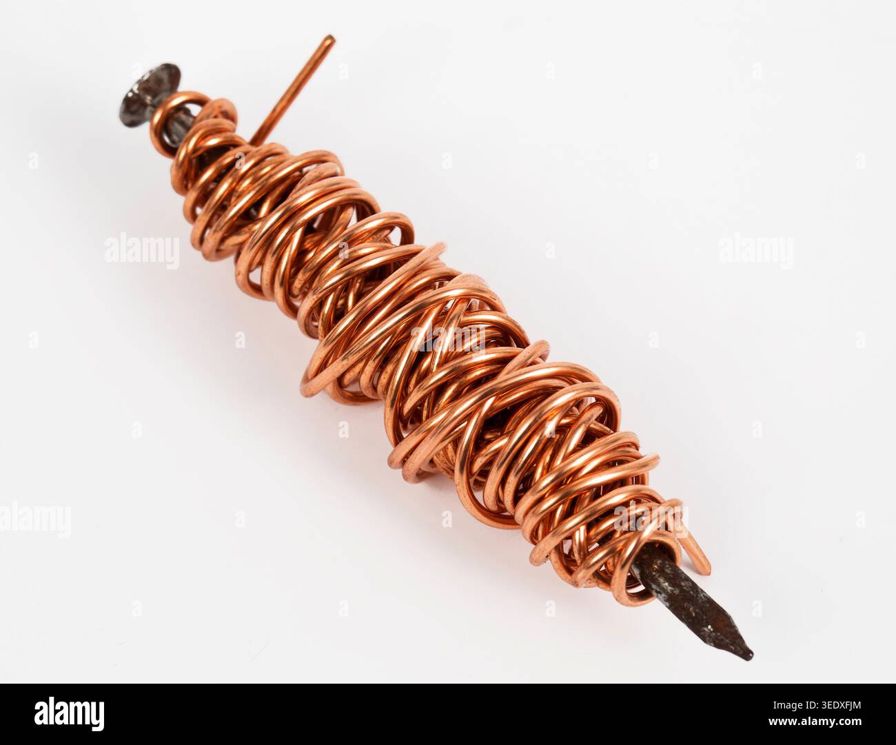 esperimento fisico per dimostrare i principi dell'elettromagnetismo. Un chiodo è avvolto con una filettatura di rame come una bobina o un argano. Quando si tratta di un veicolo elettrico Foto Stock
