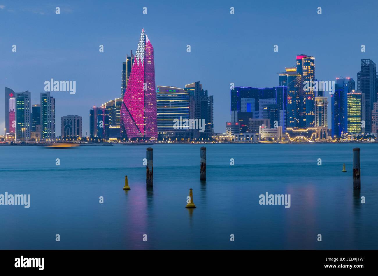Splendido skyline di Doha all'ora blu con la Torre Burj al Mana illuminata al centro. Foto Stock