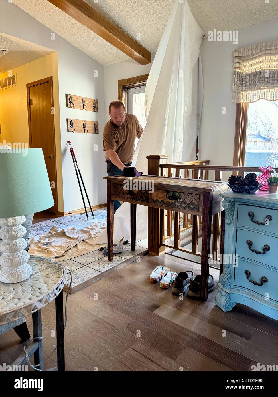 Un operaio caucasico prepara materiale di protezione in plastica prima di iniziare il lavoro installando una nuova porta d'ingresso in una casa residenziale a Wichita, Kansas, Stati Uniti Foto Stock