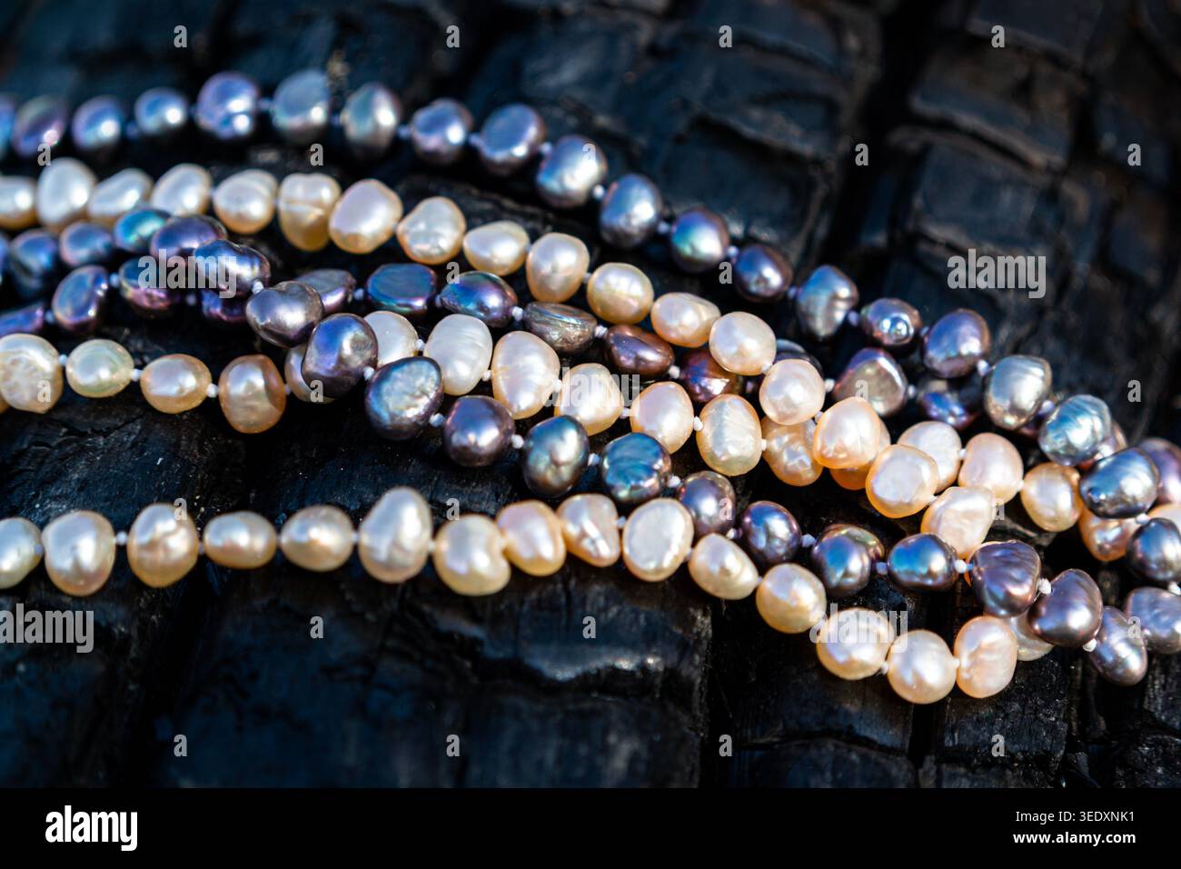 Collane di perle d'acqua dolce su sfondo in legno scuro testurizzato, gioielli di lusso da vicino Foto Stock