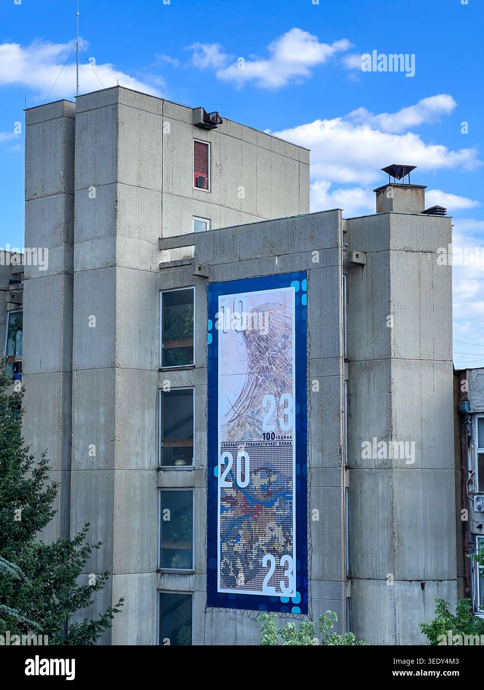 Edificio brutalista e concreto dell'Istituto di pianificazione urbana di Belgrado sotto il cielo blu con nuvole. - Immagine stock catturata con smartphone