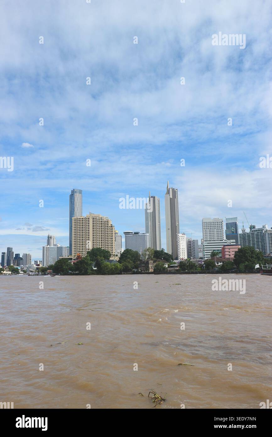 Skyline di Bangkok accanto al fiume Chao Phraya, caratterizzato da grattacieli moderni e da un paesaggio urbano di prima qualità sul lungomare Foto Stock