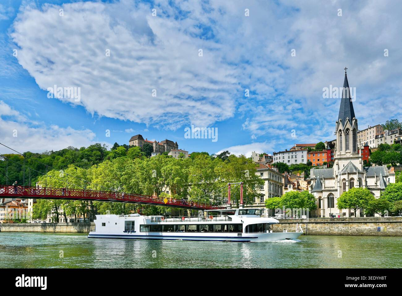 Barca di turisti sul fiume Saône, passando di fronte alla famosa chiesa di Saint Georges nel quartiere della vecchia lione in Francia in primavera. Foto Stock