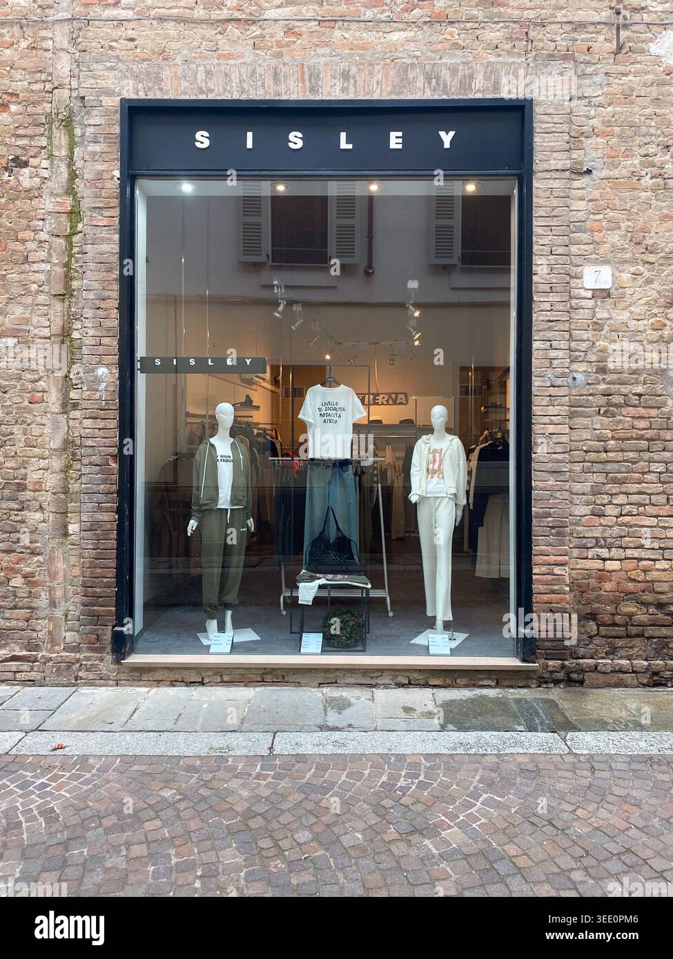 Cremona, Italia 9 aprile 2026 Sisley Storefront con grande vetrata che espone la collezione di moda attuale su manichini presso la strada urbana in mattoni faca Foto Stock