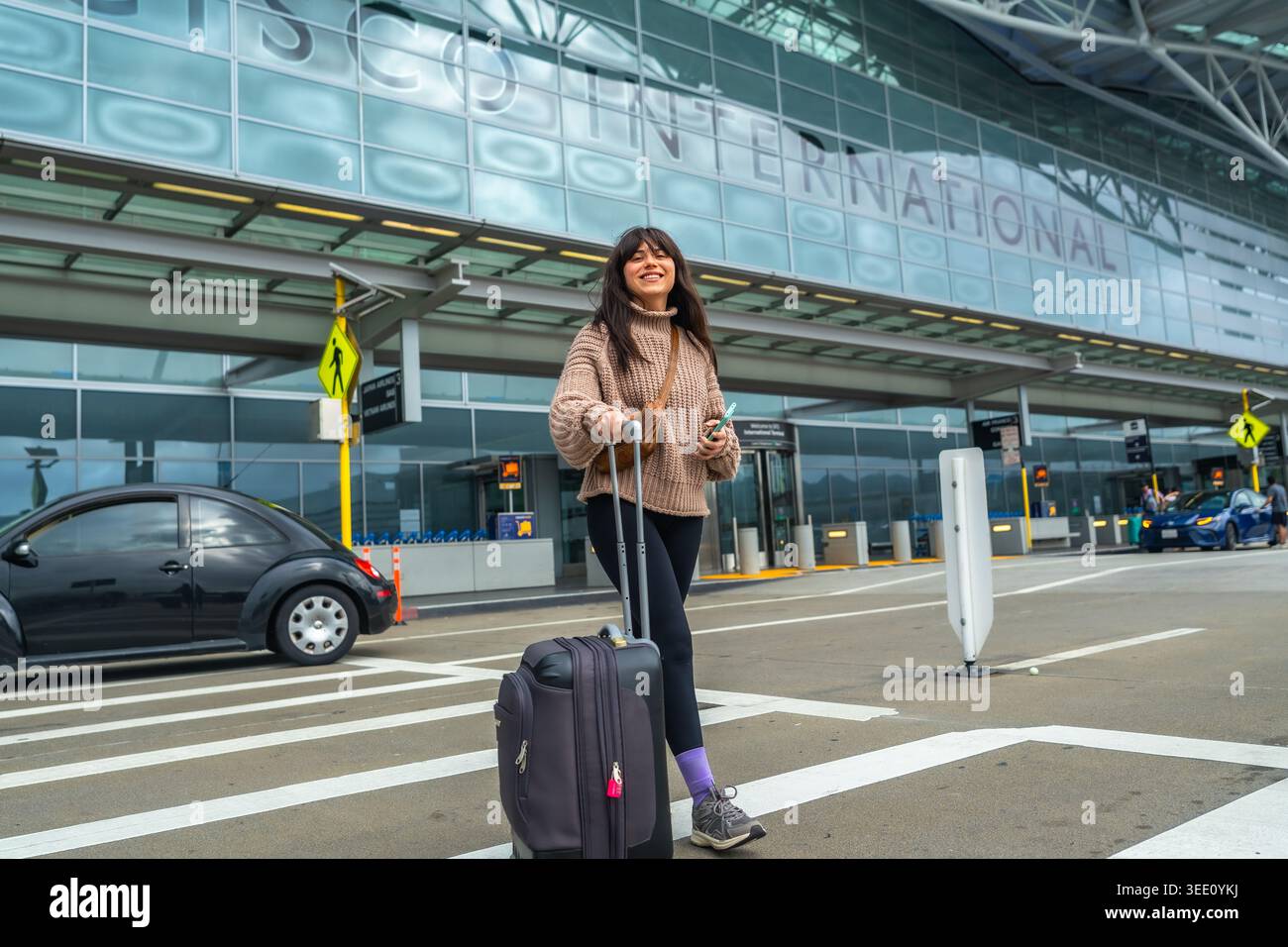 Donna che viaggia all'aeroporto internazionale di san francisco con bagagli Foto Stock