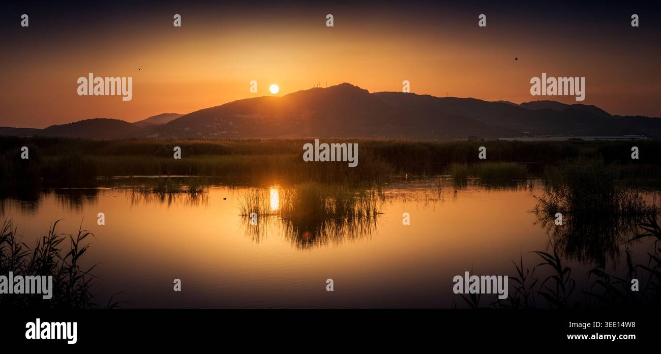 Splendido e tranquillo lago al tramonto con riflessi colorati del cielo Foto Stock