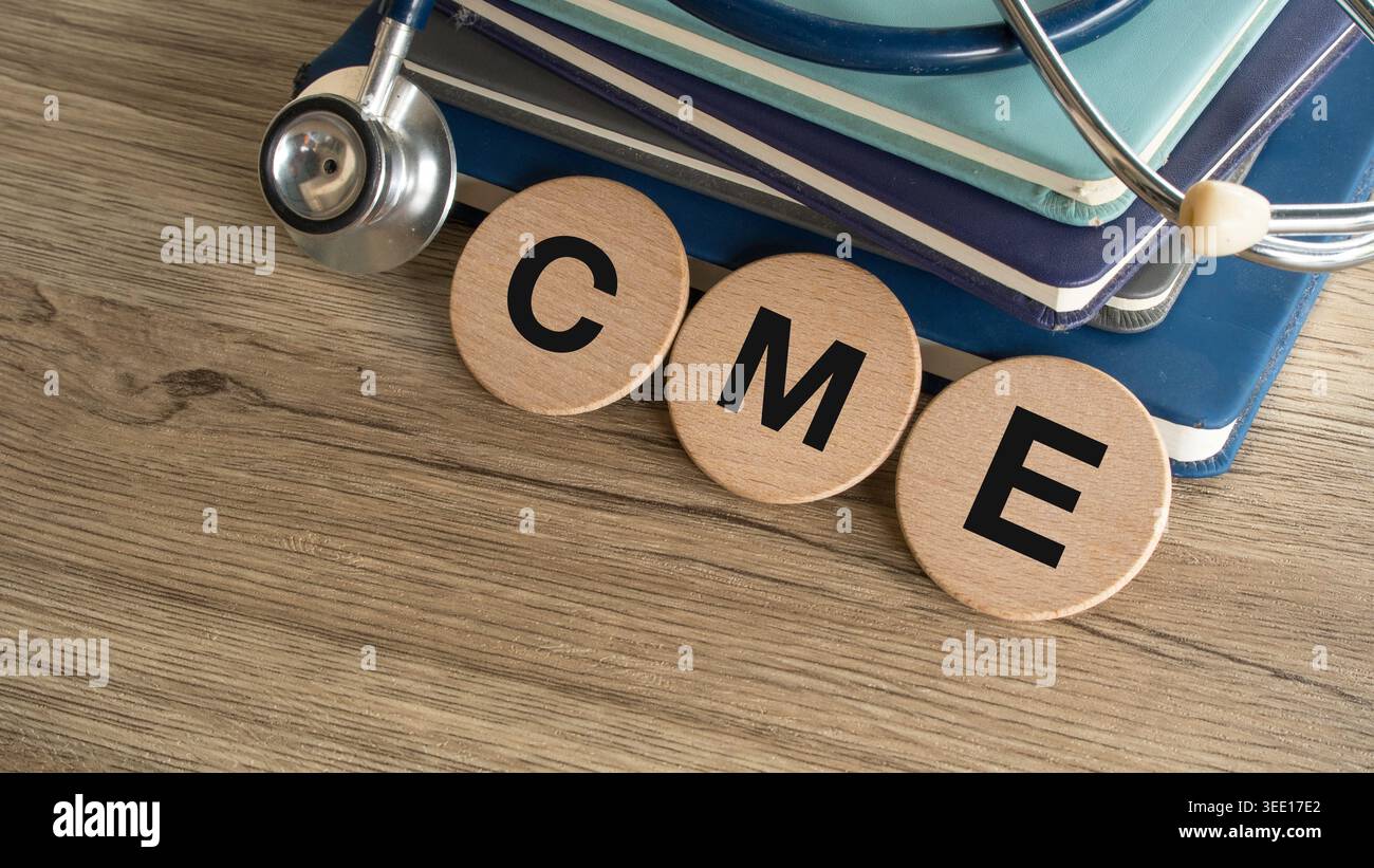 Concetto di formazione medica continua con stetoscopio, libri medici e piastrelle di lettere in legno su uno sfondo in legno per i professionisti sanitari. Foto Stock