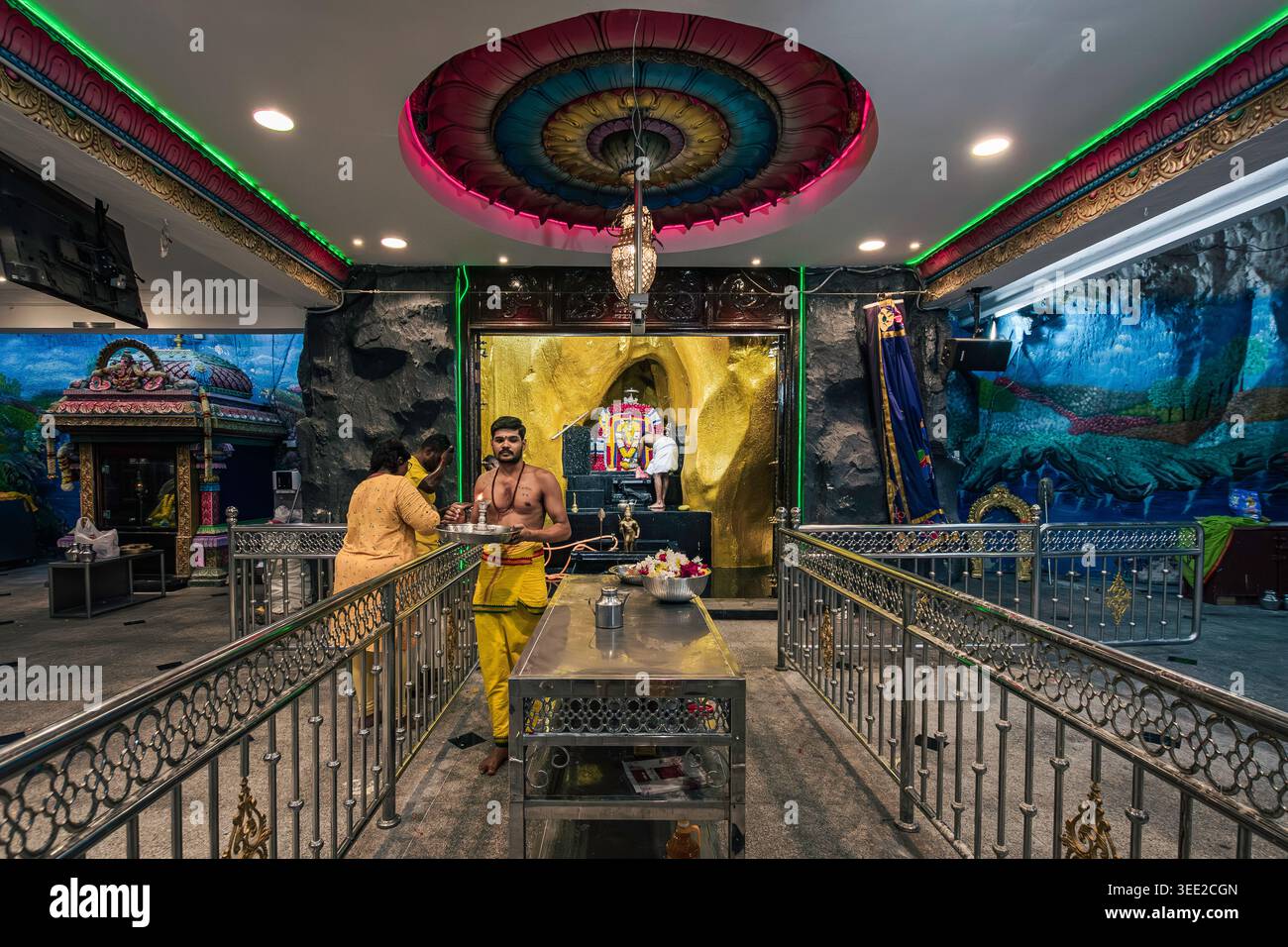 Sacerdote indù che esegue rituali all'interno di un tempio delle grotte di Batu, Kuala Lumpur, Malesia, sacro santuario dedicato al Signore Murugan Foto Stock