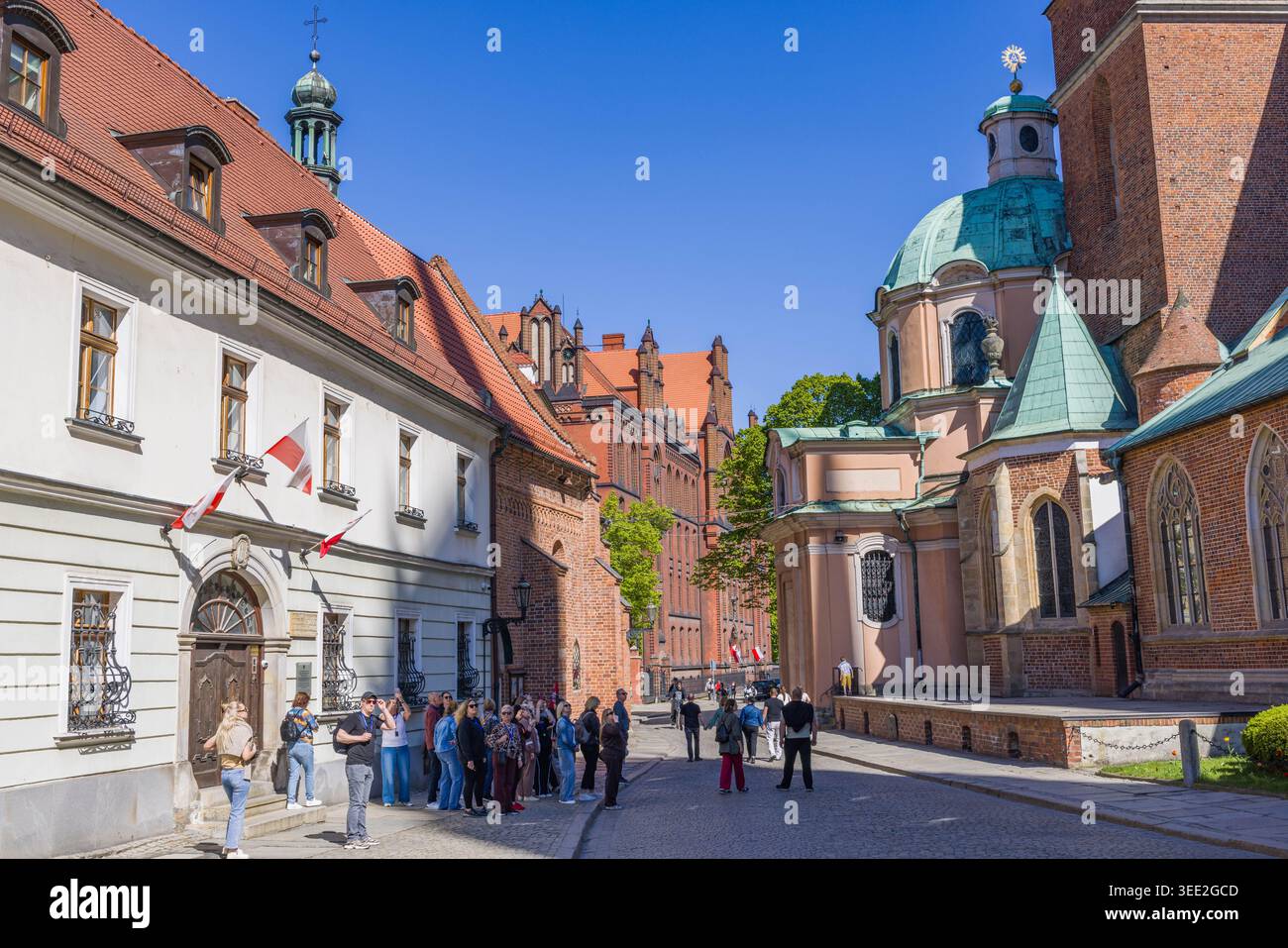 Scena storica di strada su Ostrów Tumski con la cattedrale di Breslavia, il mercato coperto e i visitatori che esplorano il patrimonio culturale della città. Foto Stock