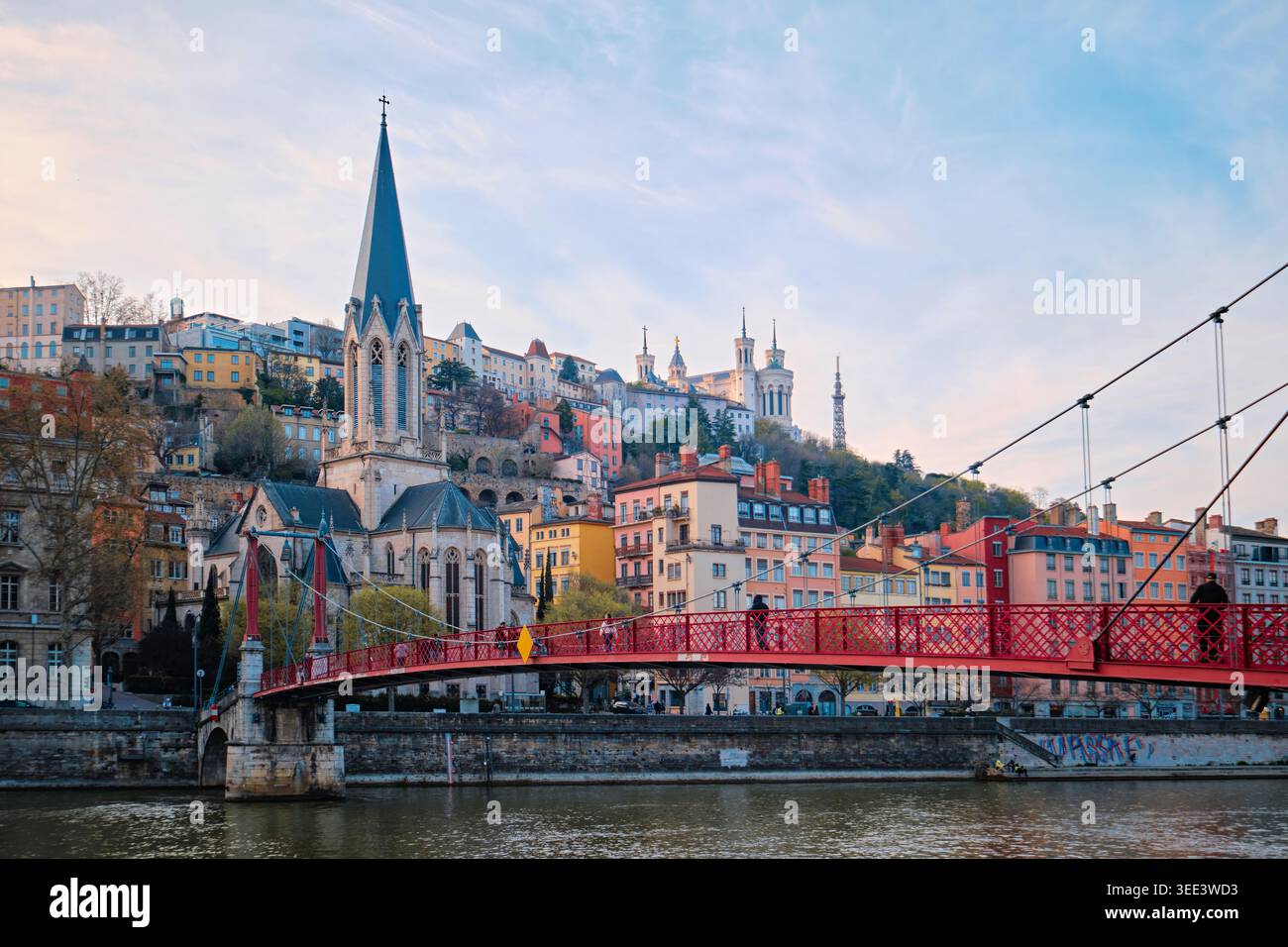 Lione, Francia - 19 marzo 2026: Vista panoramica del fiume Saone, ponte rosso Passerelle Saint-Georges, Eglise Saint-Georges e collina Fourviere Foto Stock