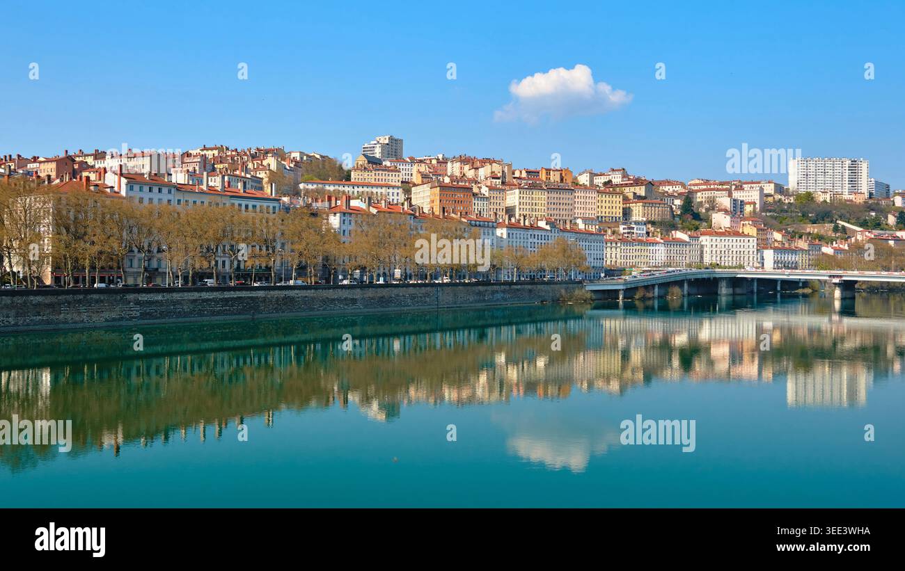 Lione, Francia - 19 marzo 2026: Vista panoramica degli edifici storici lungo il fiume Saone con riflessi perfetti sulla superficie dell'acqua Foto Stock