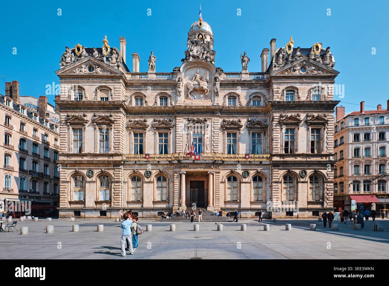 Lione, Francia - 19 marzo 2026: Lo storico edificio del municipio dell'Hotel de Ville de Lyon in Place des Terreaux, sotto un cielo azzurro e limpido di giorno Foto Stock