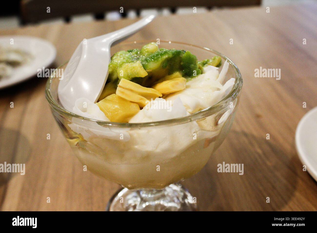 Es Teler o cocktail di frutta indonesiana servito con avocado, carne di cocco, gelatina d'erba, jackfruit, servito con latte di cocco, latte condensato e ghiaccio Foto Stock