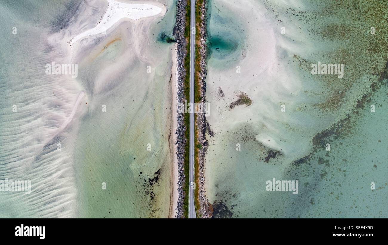 Vista aerea dall'alto verso il basso delle distese di marea poco profonde con ipnotiche acque turchesi che creano formazioni ondulate naturali e texture sabbiose divise da caus Foto Stock