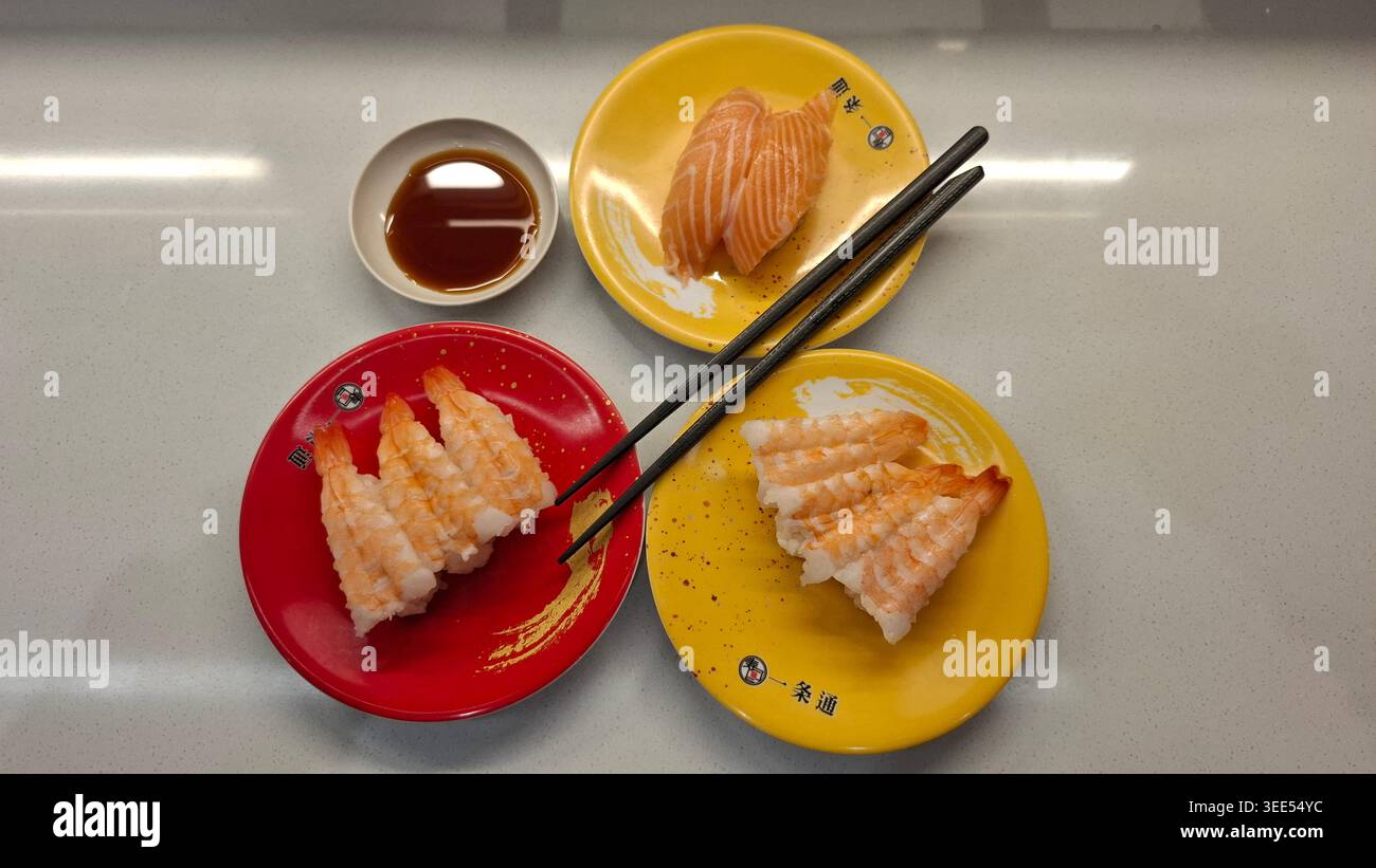 Sushi Nigiri assortiti su piatti colorati vista dall'alto Foto Stock