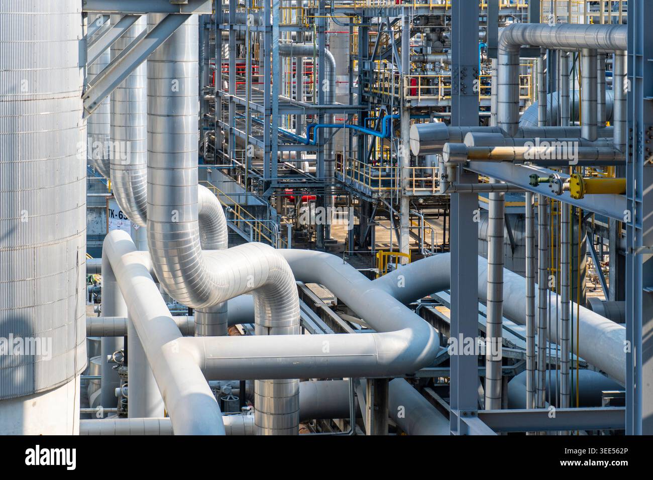Primo piano di un sistema di scaffali per tubi di grandi dimensioni e di strutture di tubazioni metalliche all'interno di un impianto a gas. Foto Stock
