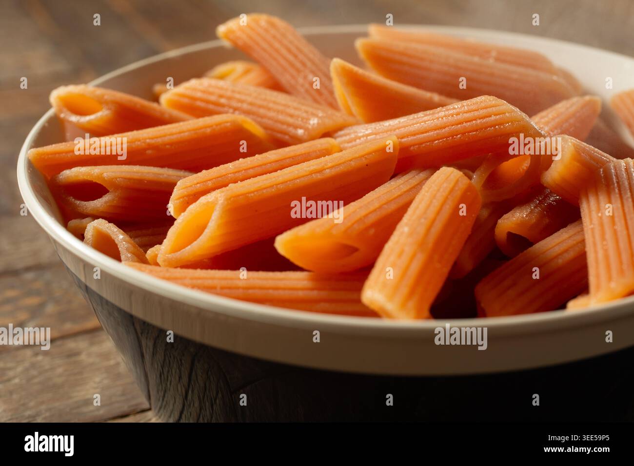 Vista ravvicinata di una ciotola di penne di lenticchie rosse cotte senza glutine. Foto Stock
