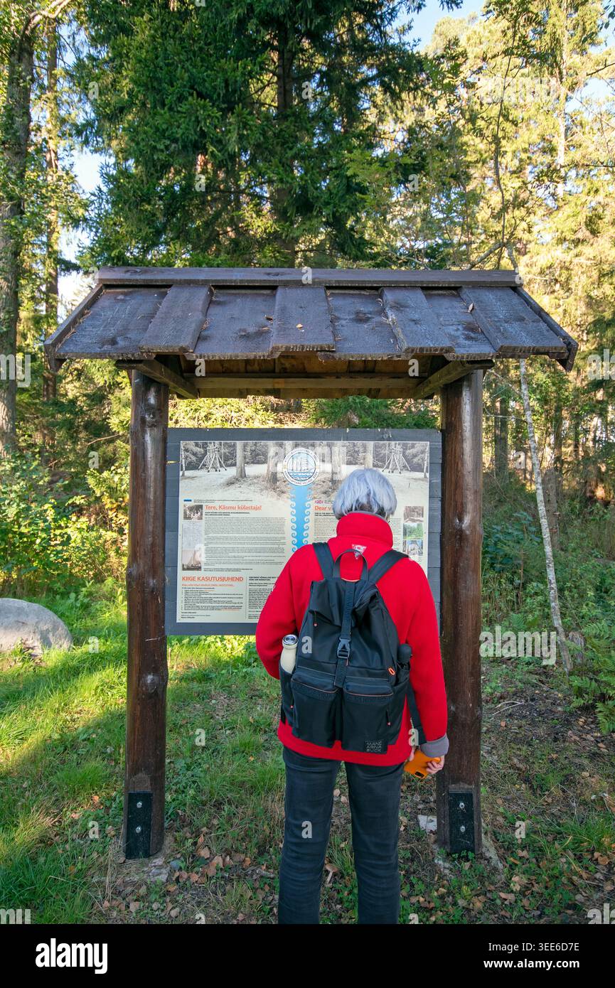Escursionista che legge un cartello informativo nel Parco Nazionale di Lahemaa, penisola di Kasmu, Estonia, Europa Foto Stock