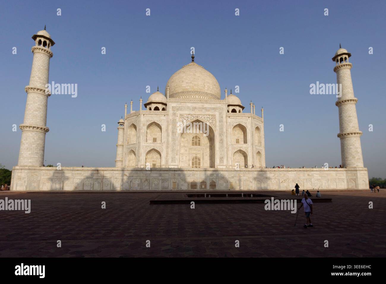L'iconica facciata in marmo bianco del mausoleo del Taj Mahal e dei suoi minareti sotto un cielo azzurro cristallino ad Agra in India Foto Stock