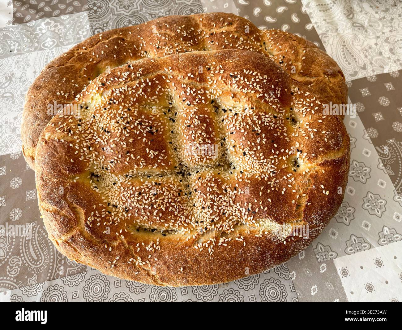 Pane tradizionale greco lagana con semi di sesamo su tavola rustica durante la Quaresima - Immagine stock catturata con smartphone