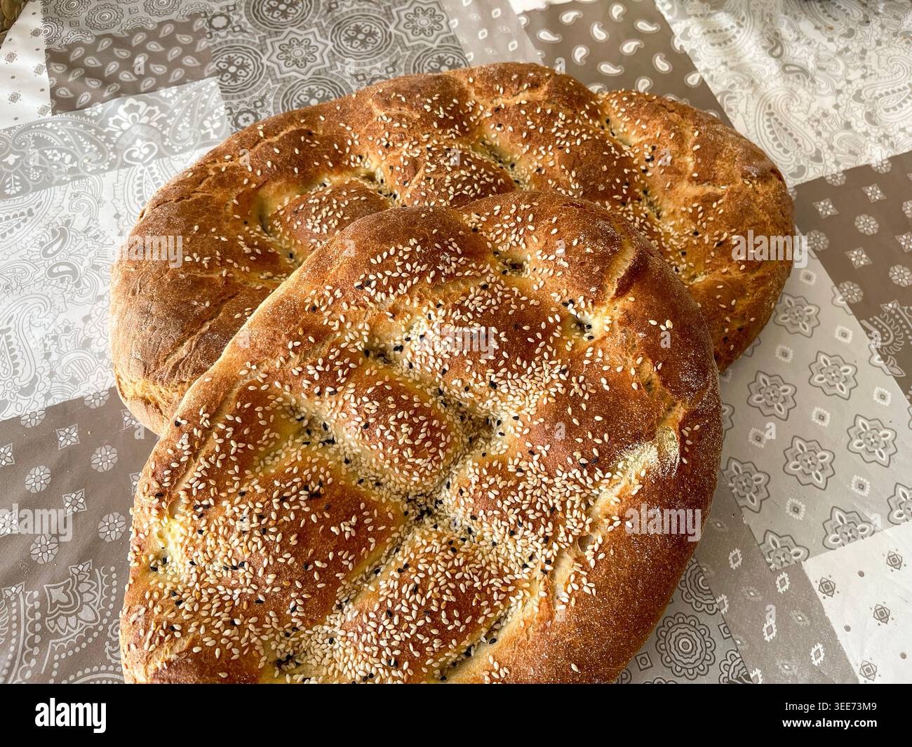 Pane tradizionale greco lagana con semi di sesamo su tavola rustica durante la Quaresima - Immagine stock catturata con smartphone