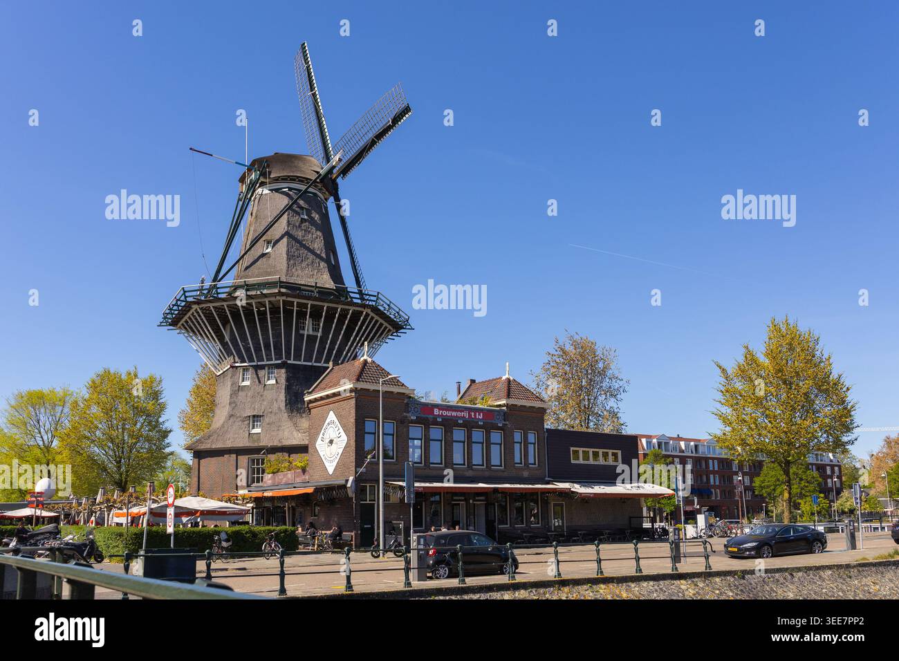 Amsterdam, Paesi Bassi - 30 aprile 2026: Birreria Brouwerij t IJ e mulino a vento tradizionale olandese ad Amsterdam, Paesi Bassi. Foto Stock