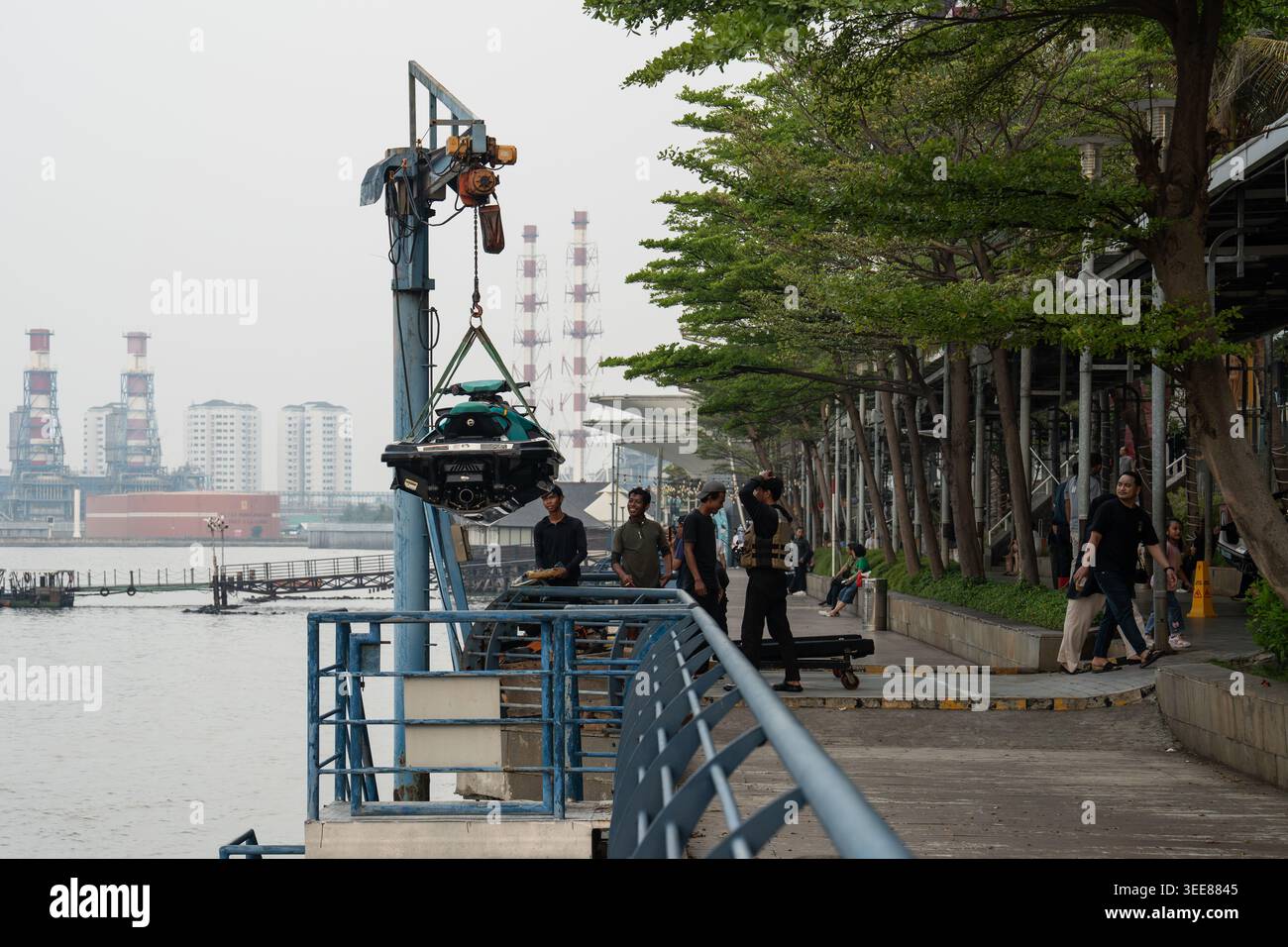 GIACARTA, INDONESIA, 9 maggio 2026 - l'equipaggio di servizio solleva un jetski con una gru sul lungomare del Baywalk Mall dopo l'orario di chiusura, preparandolo per la notte Foto Stock