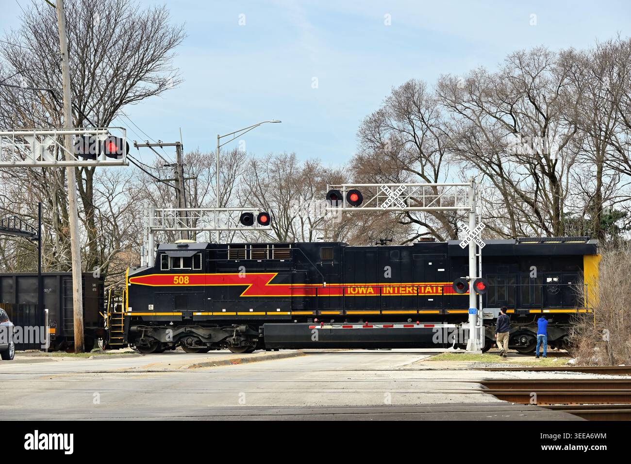 Blue Island, Illinois, Stati Uniti. Una locomotiva della Iowa Interstate Railroad conduce un treno merci attraverso un passaggio ben protetto nella subruban Chicago. Foto Stock