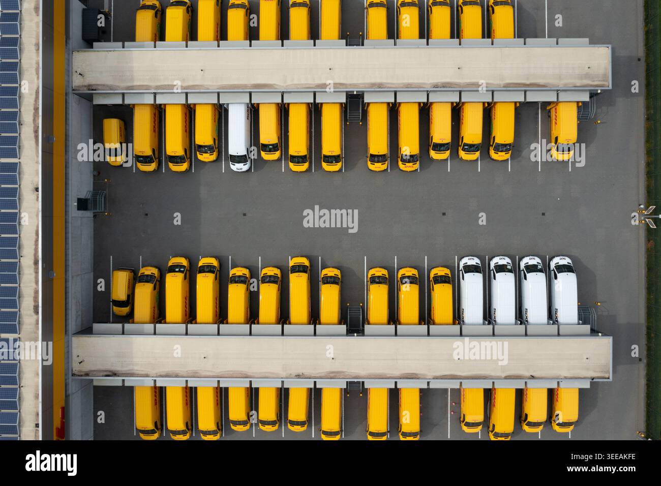 01 settembre 2019: Veduta aerea dei furgoni DHL gialli e bianchi parcheggiati in file ordinate presso un magazzino logistico di carico. Foto Stock