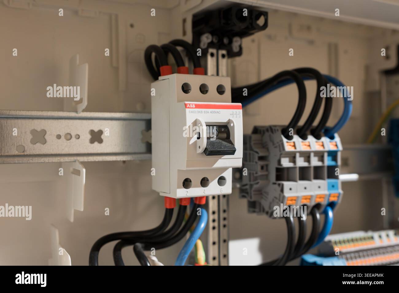 Interruttore principale da 3 KB ABB E463 nella scatola fusibili per uso domestico. Interruttore on-off montato su guida DIN. Primo piano dei componenti elettrici nella tecnologia degli alloggiamenti. Foto Stock
