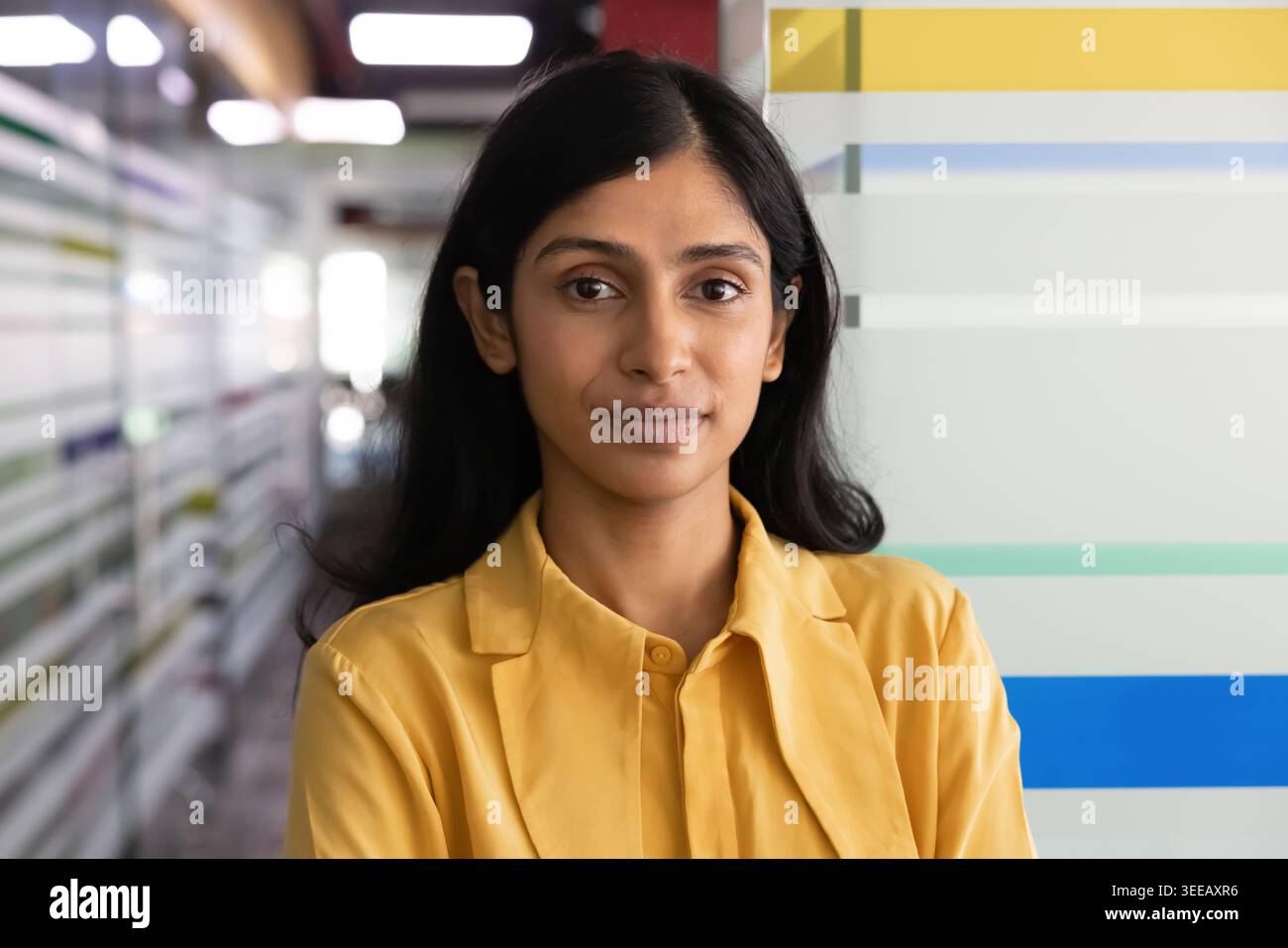 Colpo alla testa di una donna d'affari indiana che posa per un ritratto in ufficio al chiuso Foto Stock