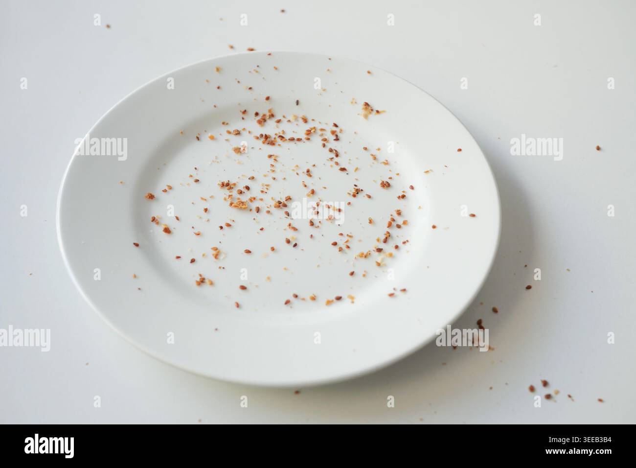 Pulire il piatto con le briciole lasciate dopo un pasto Foto Stock