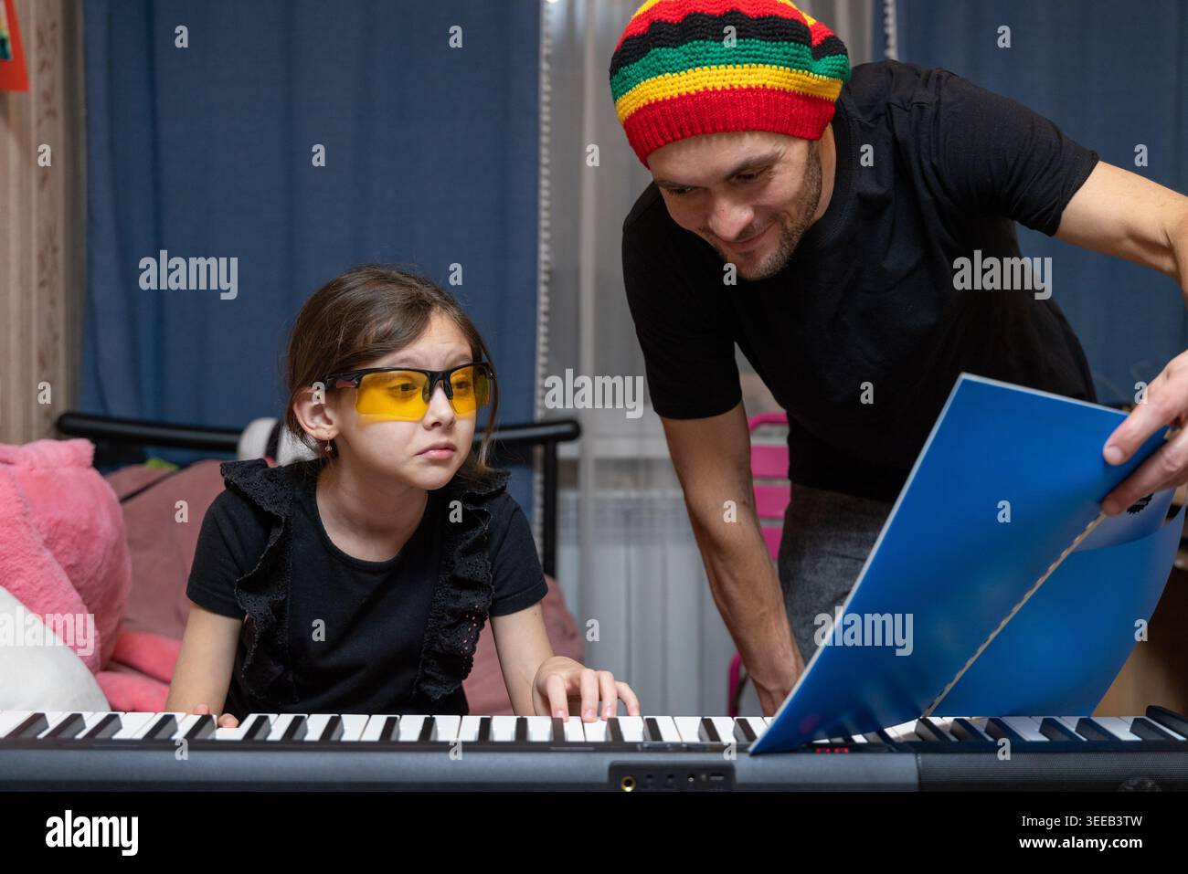 Padre che insegna musica a casa a figlia Foto Stock