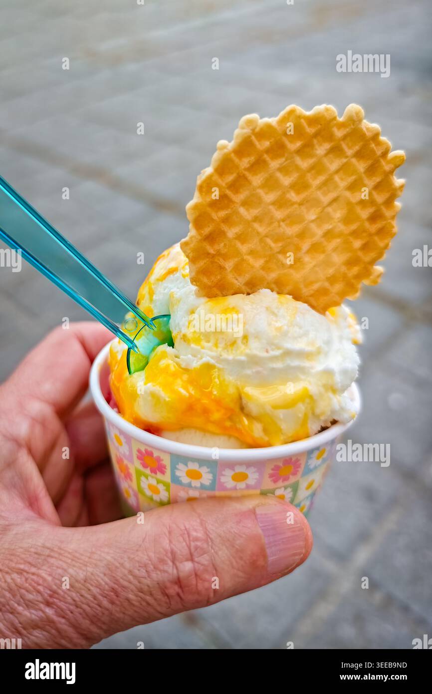 Gelato in vasca con biscotti e cucchiaio in una bancarella di cibo di strada in estate. Foto Stock