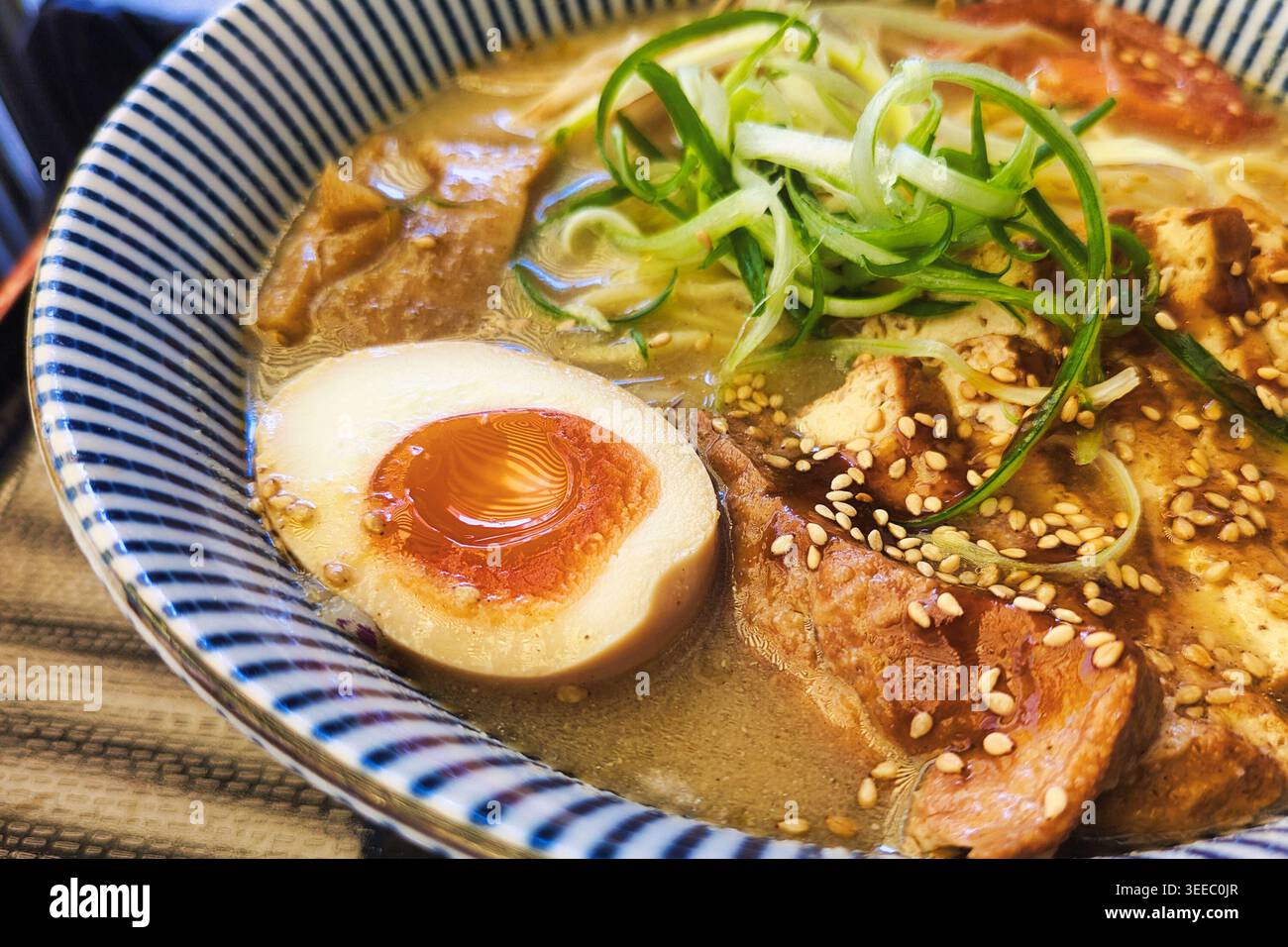 Ramen di tofu vegetariano con brodo di miso, uova sode soffici, germogli di bambù, germogli di soia, cipolle e cipolle primaverili nella zuppa di spaghetti giapponese Foto Stock