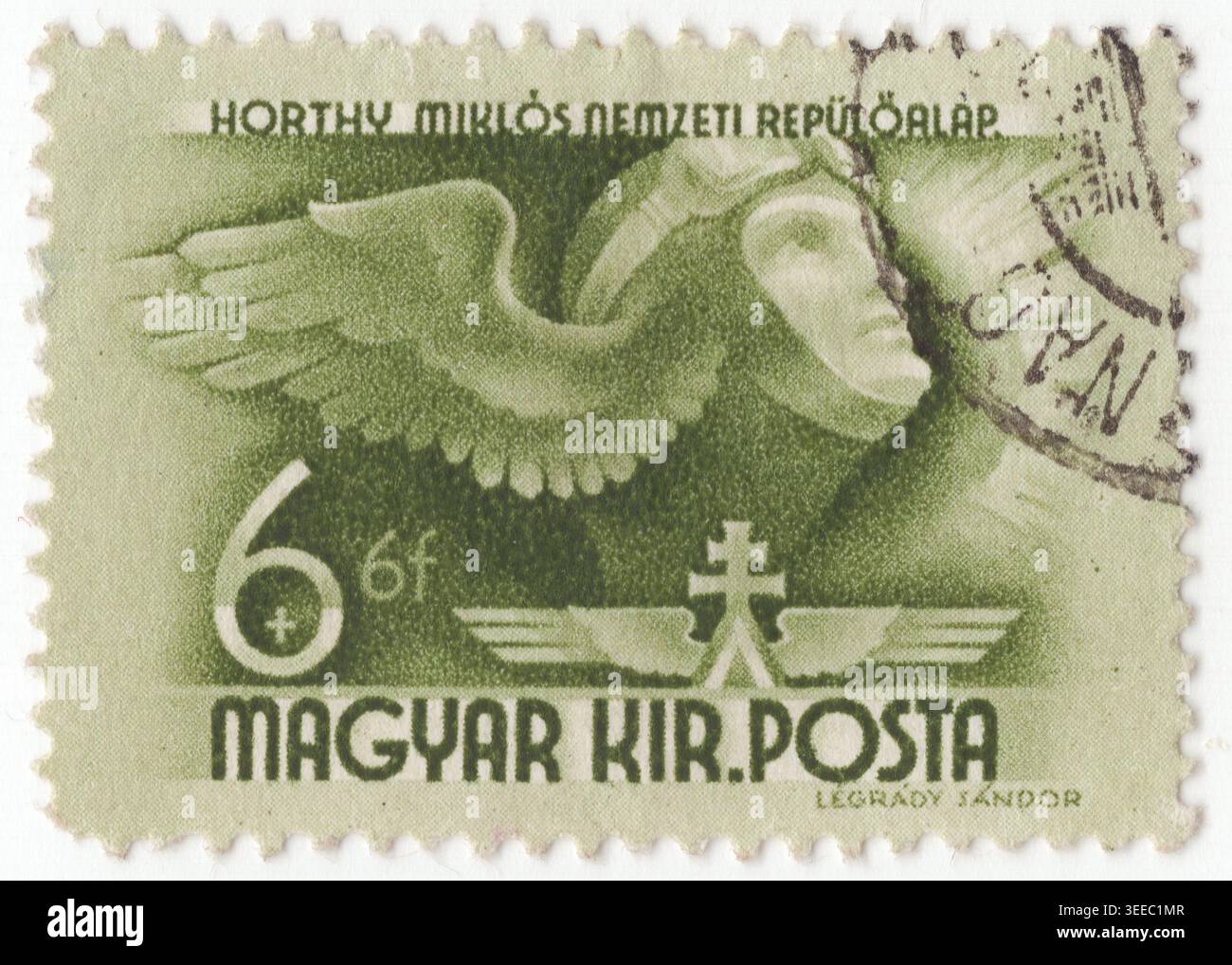 UNGHERIA - 1941 marzo 24: Francobollo semi-postale 6+6 verde oliva raffigurante la testa alata del pilota con ali stilizzate, simbolo del progresso aereo e nazionale. Emessa per il Fondo nazionale per l'aviazione di Miklós Horthy, serviva a raccogliere capitali per lo sviluppo del volo ungherese. Il design presenta la testa di un aviatore in un casco da volo accanto a una grande ala, con un simbolo a doppia croce alata sotto. Surtax per finanziare l'addestramento di piloti civili e militari attraverso il Horthy National Aviation Fund Foto Stock