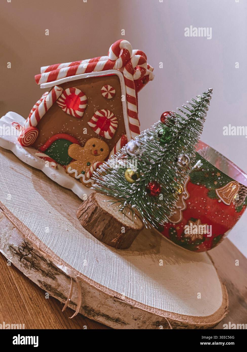 Decorazioni casalinghe di pan di zenzero con mini albero di Natale su tavola di legno, accogliente scena festiva - Immagine stock catturata con smartphone